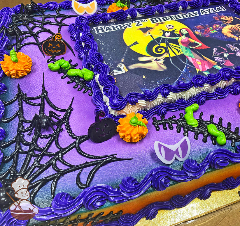 Purple and orange sheet cake with black spiderwebs, plastic spiders, orange pumpkins, and purple buttercream borders.