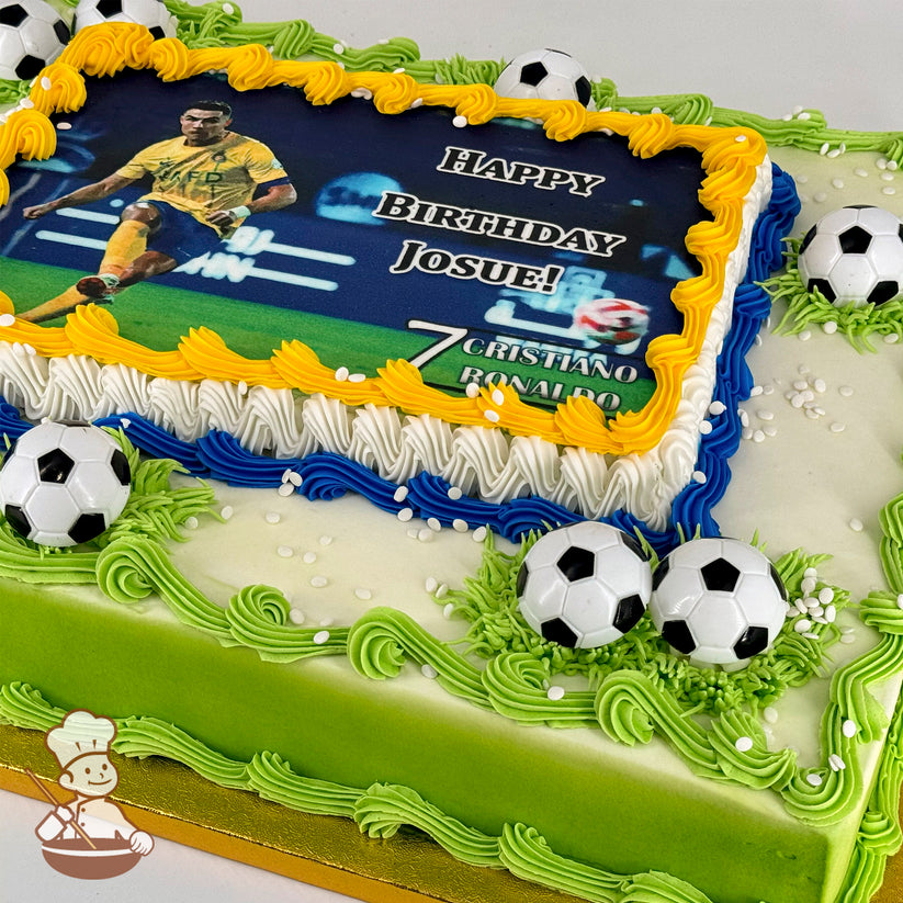 Sheet cake with green, white, and blue buttercream borders, yellow accents, plastic soccer ball decorations, and white sprinkles.