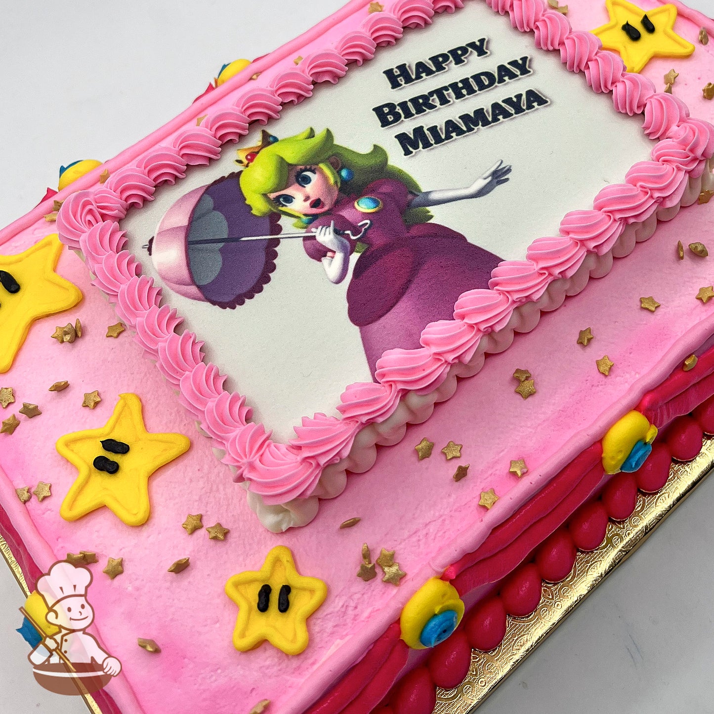 Pink sheet cake with a printed photo layer, pink buttercream border, yellow star decorations, and gold star sprinkles.