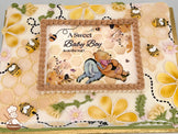 Sheet cake with honeycomb piping, yellow and cream buttercream flowers, buttercream bees, green leaves, and a printed photo layer framed by piped frosting.
