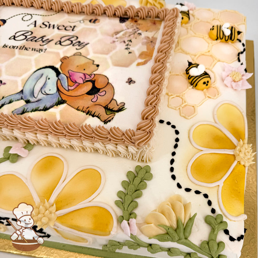 Sheet cake with honeycomb piping, yellow and cream buttercream flowers, buttercream bees, green leaves, and a printed photo layer framed by piped frosting.