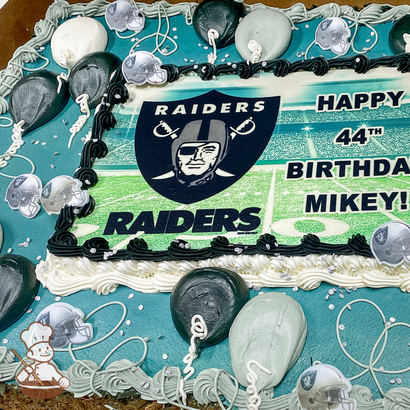 Sheet cake with gray and black buttercream balloons, plastic Raiders helmets, and black icing border. White and gray swirls and sprinkles decorate the edges.
