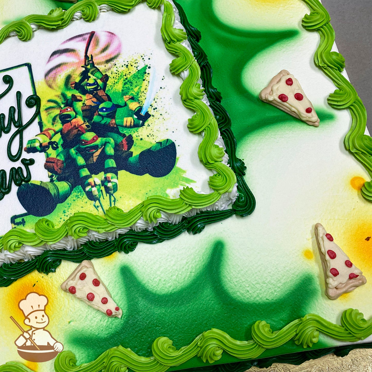 Sheet cake with green and white buttercream swirl trims, airbrushed green and yellow accents, and buttercream pizza slice decorations with red toppings.