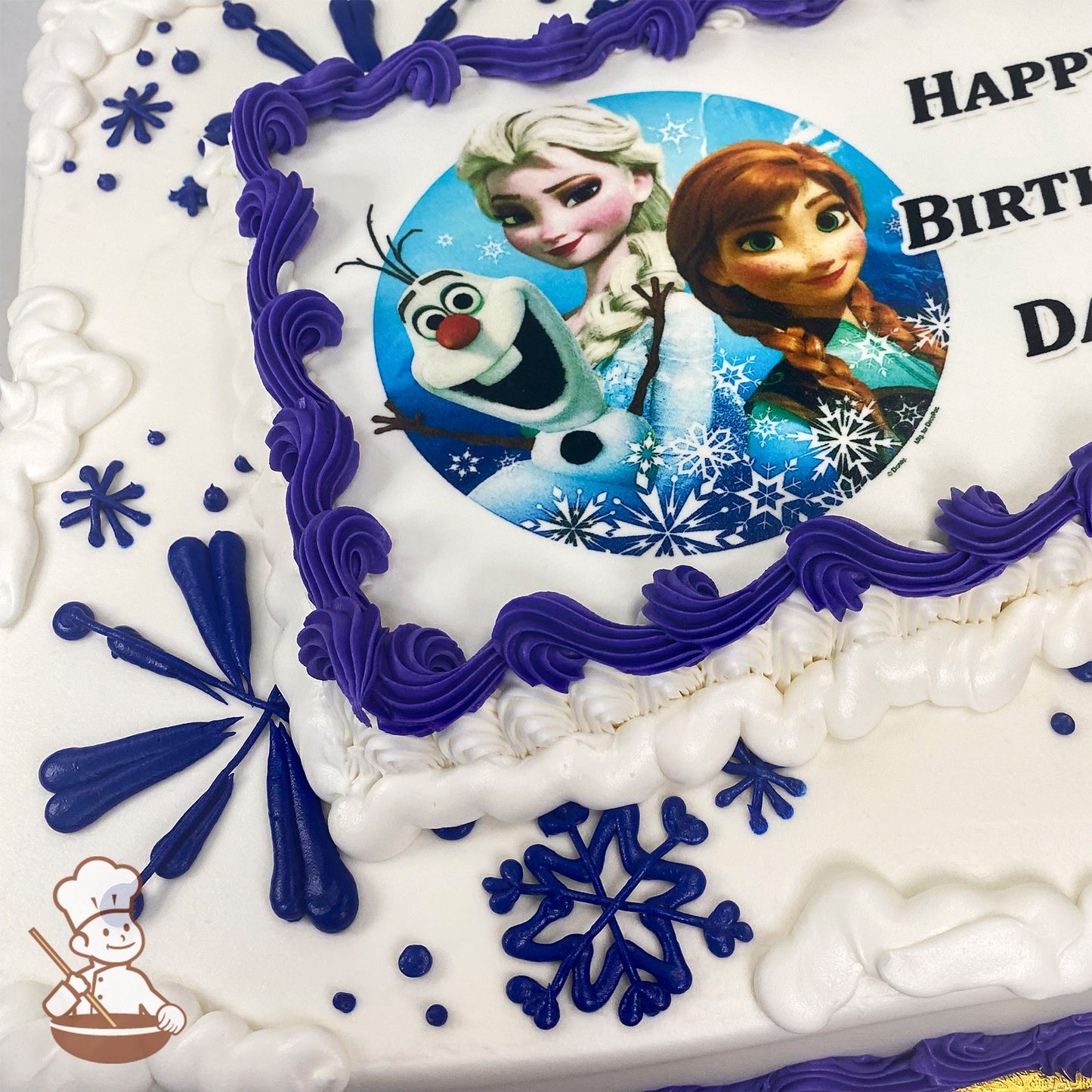 Sheet cake with white frosting, purple piped borders, blue and purple snowflake designs, and a printed photo layer in the center.