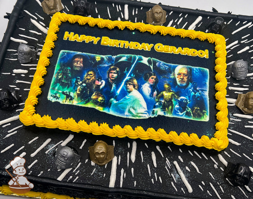 Sheet cake with a Star Wars theme, featuring a yellow buttercream border around a printed image, black frosting with white streaks resembling hyperspace, and plastic Star Wars character rings as decorations.
