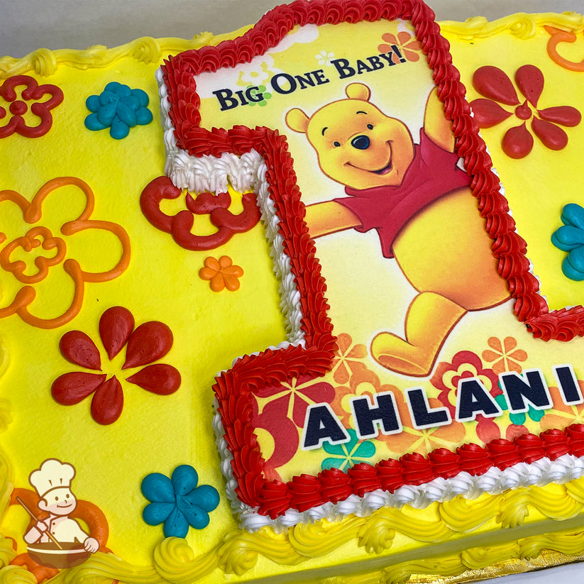 Yellow sheet cake with colorful buttercream flowers, featuring a red-bordered number 1 cutout of Winnie the Pooh in a red shirt, surrounded by floral designs.