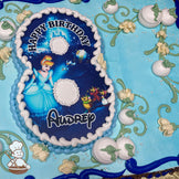 Blue sheet cake with buttercream white pumpkins, green vines, pearl bead sprinkles, and floral designs. Disney Cinderella design in shape of 8.