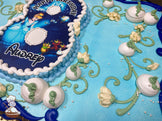 Blue sheet cake with buttercream white pumpkins, green vines, pearl bead sprinkles, and floral designs. Disney Cinderella design in shape of 8.