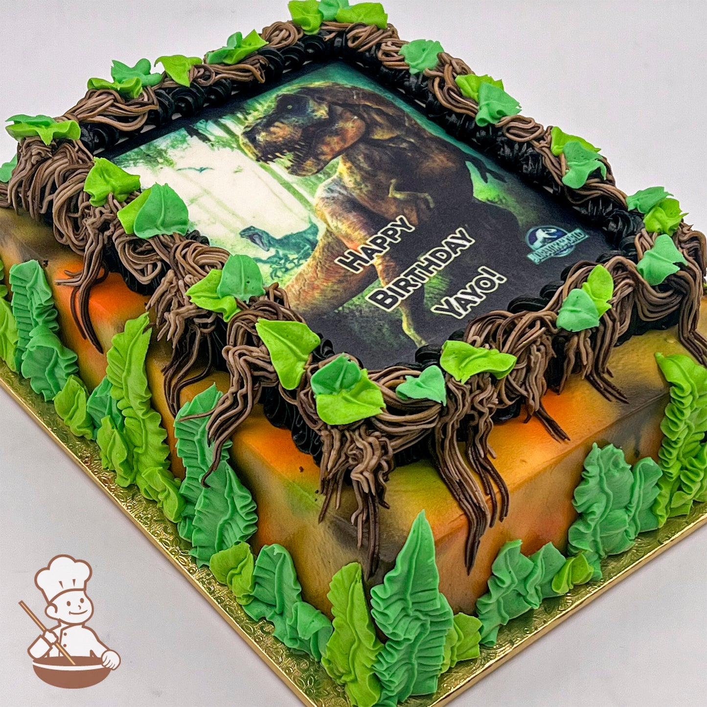 Sheet cake with jungle theme, featuring buttercream vines and green leaves around a printed photo layer.