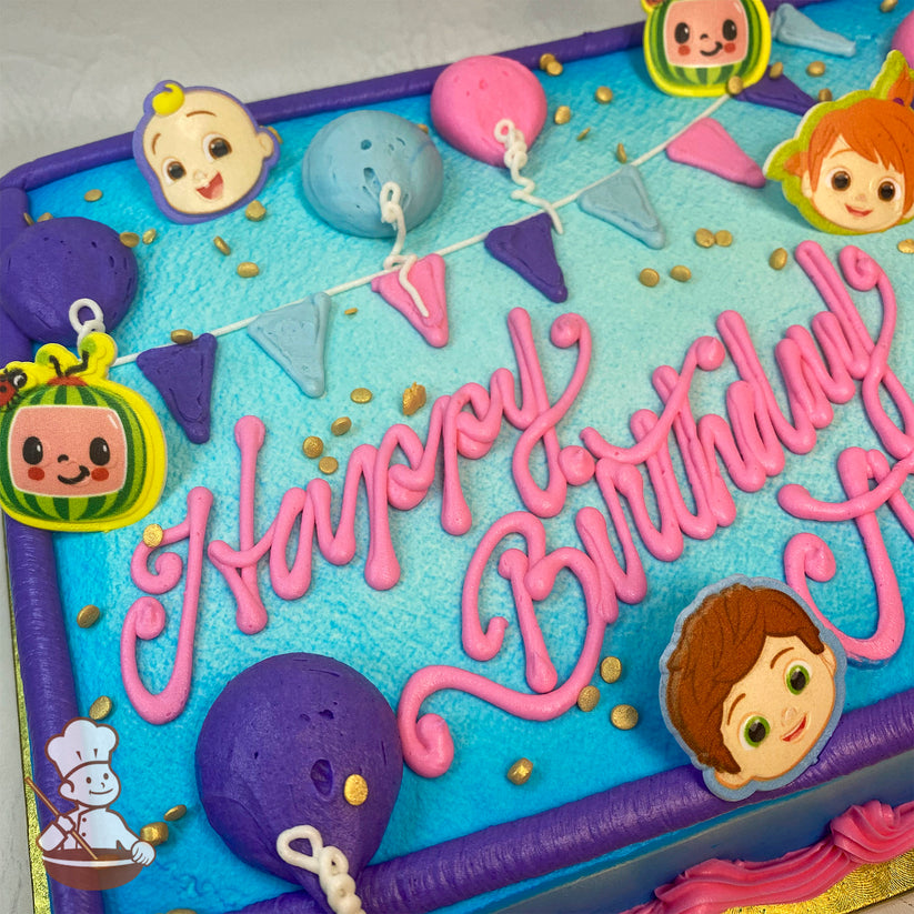 Sheet cake with blue icing, pink script, Cocomelon character plastic toppers, colorful balloons, triangular party banners, and gold sprinkles.