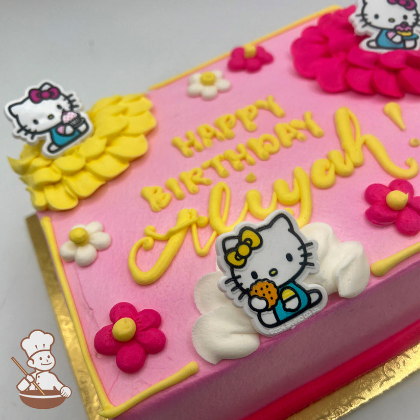 Pink sheet cake with buttercream decorations, featuring plastic Hello Kitty ring toppers, yellow, white and pink ruffles, and daisies.