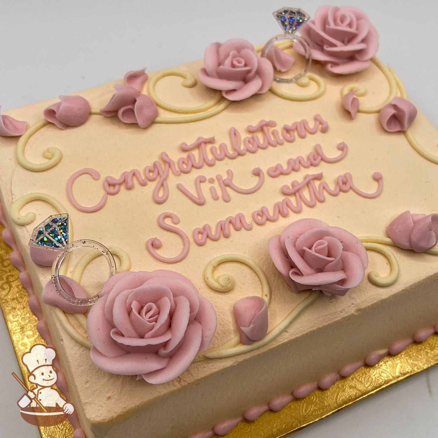 Ivory sheet cake with buttercream swirls, pink buttercream roses, and plastic diamond ring picks.