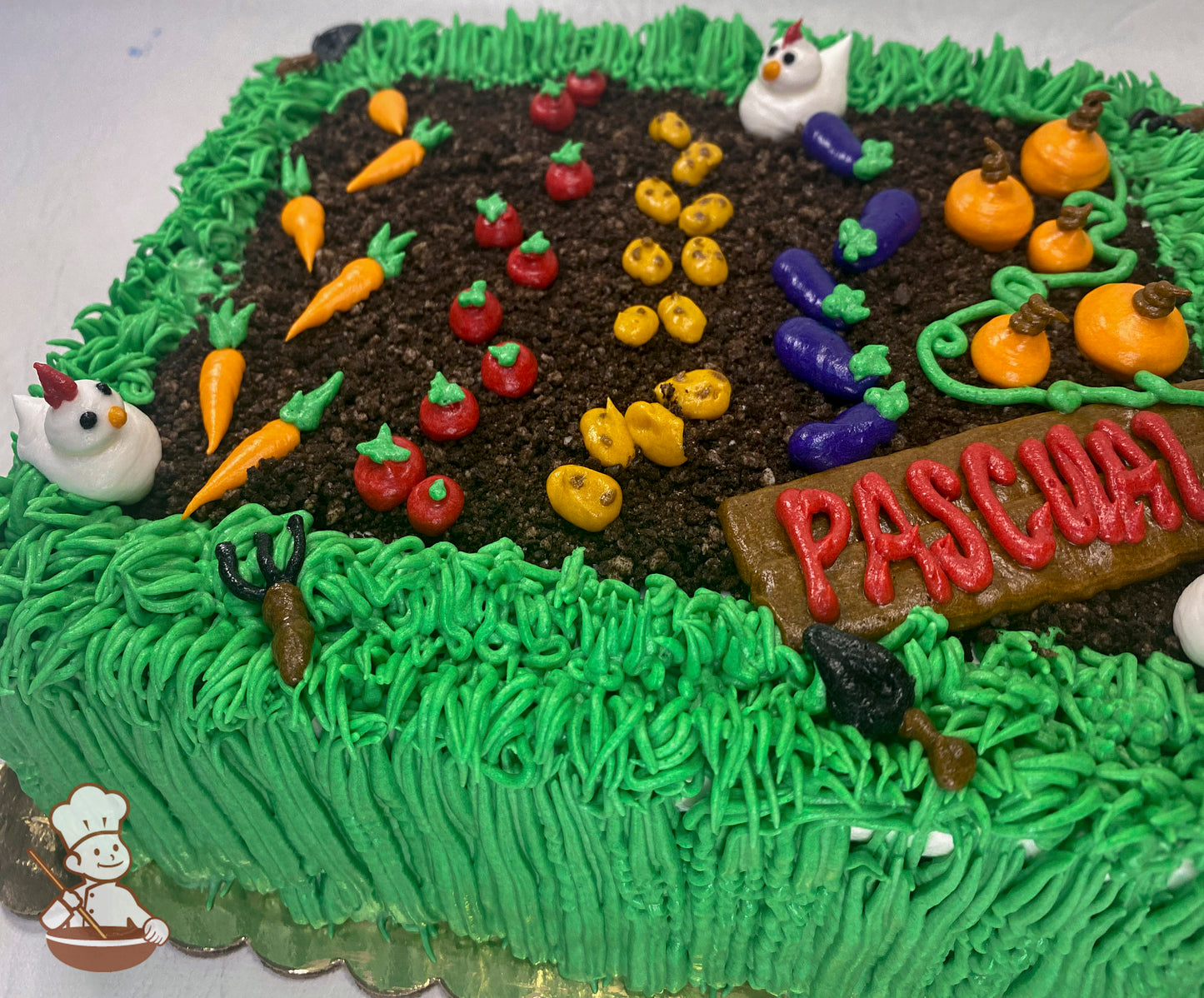 Sheet cake decorated as a garden with buttercream grass, dirt made of cake crumbs, rows of vegetables like carrots, tomatoes, and pumpkins, and small chicken figures.