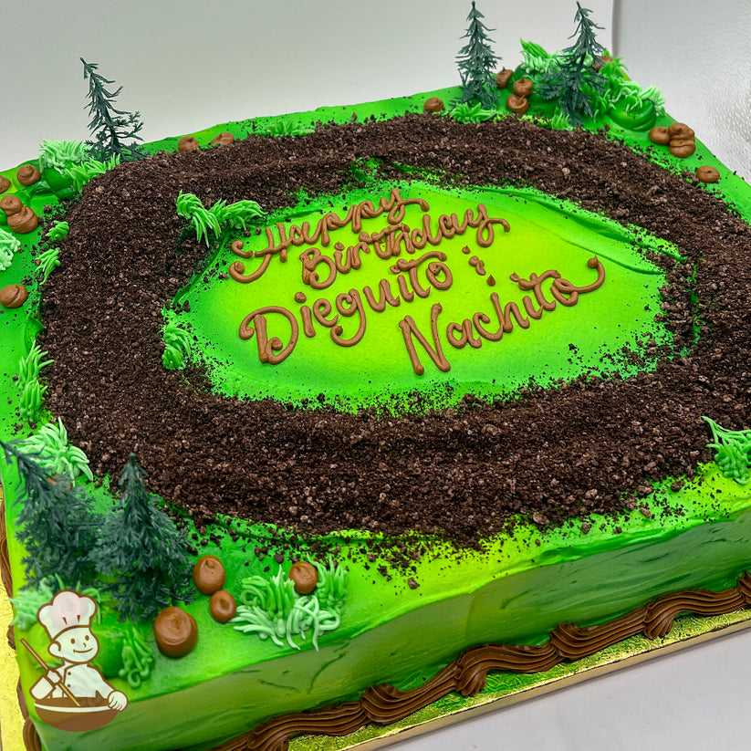 Sheet cake with a green base, a round "dirt" track made of chocolate cake crumbs, plastic trees, and buttercream grass and rocks.