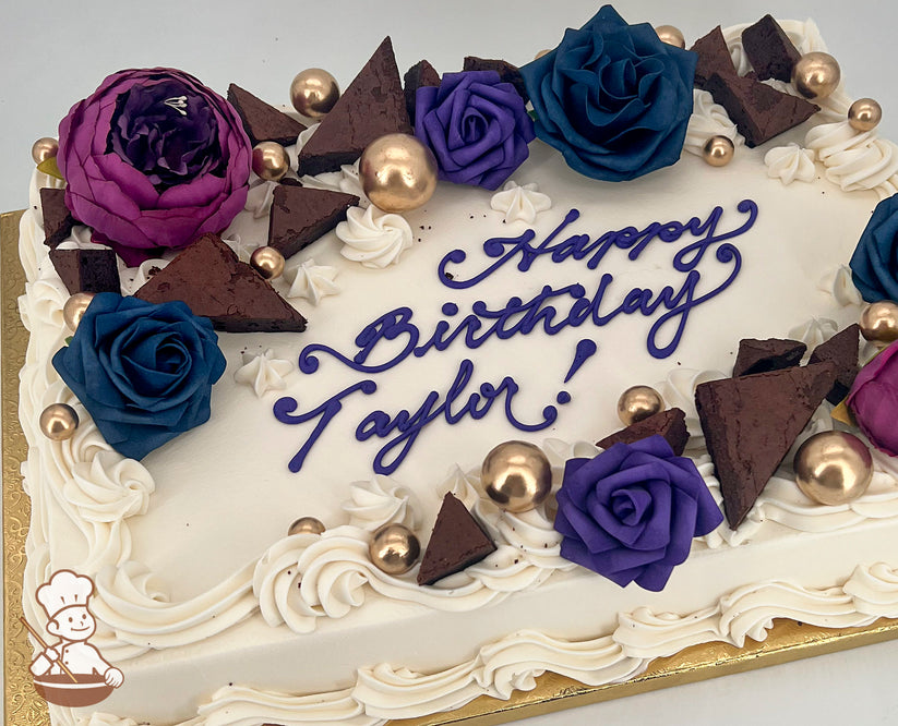 Sheet cake with white frosting, decorated with purple, blue, and magenta silk and foam flowers, chocolate brownie triangles, and gold bubble toppers.