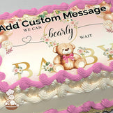 Illustration of a teddy bear with a pink bow surrounded by floral accents and balloons on a pastel pink gradient background, printed on a sheet cake.