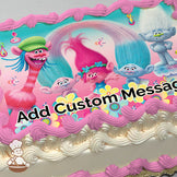 Colorful cartoon trolls with vibrant hair, including a pink-haired troll in the center, surrounded by flowers and a pink-to-blue gradient background, printed on a photo sheet cake.