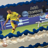 A soccer player in a yellow and blue uniform is mid-kick on a green field with a blurred stadium background. Printed on a photo sheet cake.