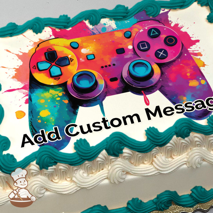 A colorful illustration of a video game controller with vibrant splashes of orange, pink, blue, and yellow on a white background, printed on a sheet cake.