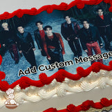 A group of seven people in dark, stylish outfits standing on a gravel path with trees in the background, printed on a photo sheet cake.