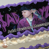 A photo of a person wearing a purple jacket with tattoos on their hand, set against a dark background with purple graffiti-style text. Printed on a sheet cake.