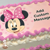 Cartoon image of Minnie Mouse smiling, wearing a pink polka-dot bow, surrounded by small pink hearts on a light pink background, printed on a sheet cake.