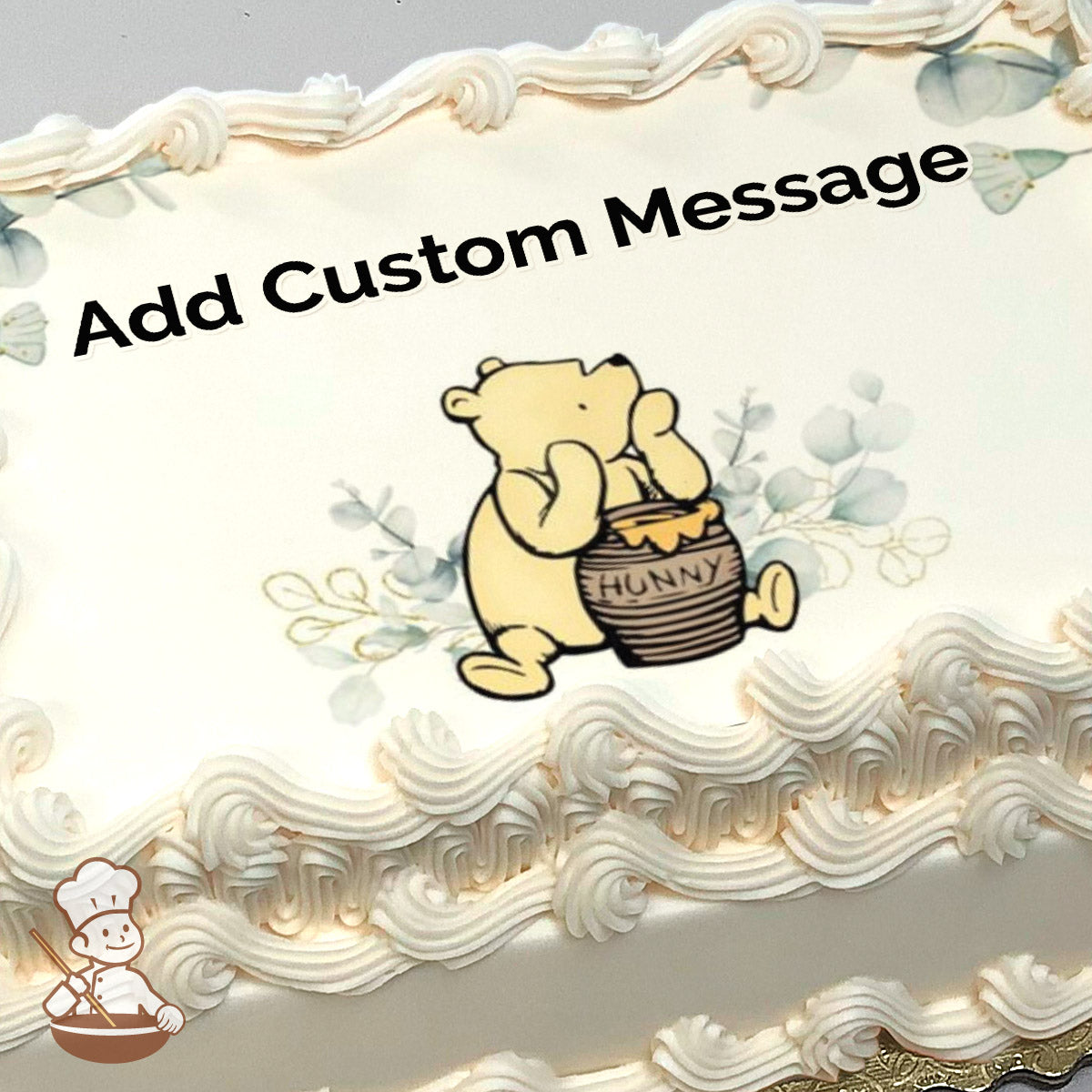 Cartoon bear with a honey pot, surrounded by light blue leaves on a white background. Image printed on a sheet cake.