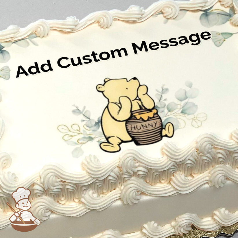 Cartoon bear with a honey pot, surrounded by light blue leaves on a white background. Image printed on a sheet cake.