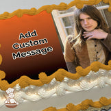 A photo of a person with long hair wearing a brown and tan outfit, sitting near a window. The background shows a blurred indoor setting. Printed on a sheet cake.