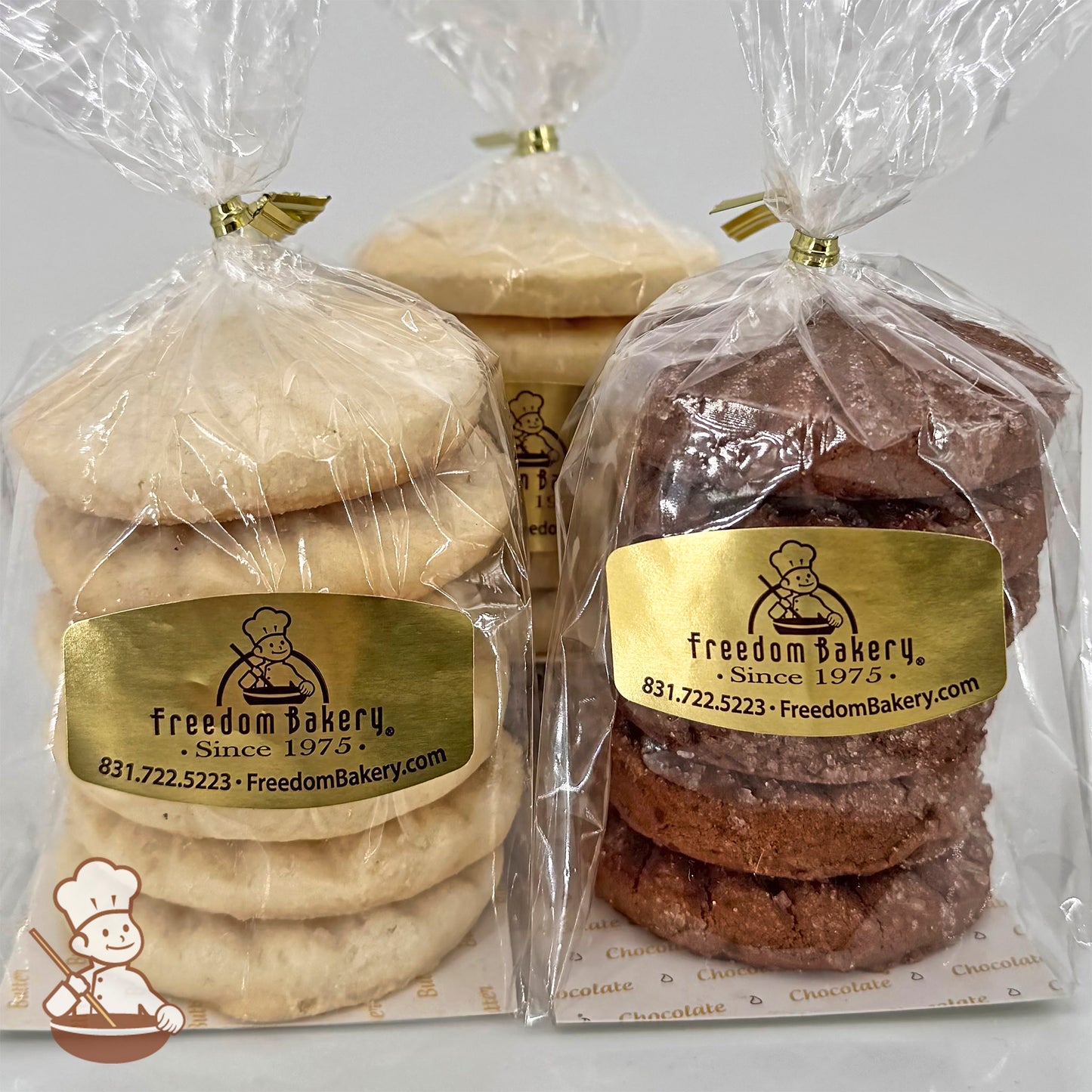 Three clear bags of shortbread cookies from Freedom Bakery are displayed. The bags contain lemon, butter, and chocolate shortbread cookies, each stacked neatly in sets of six.