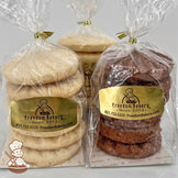Three clear bags of shortbread cookies from Freedom Bakery are displayed. The bags contain lemon, butter, and chocolate shortbread cookies, each stacked neatly in sets of six.