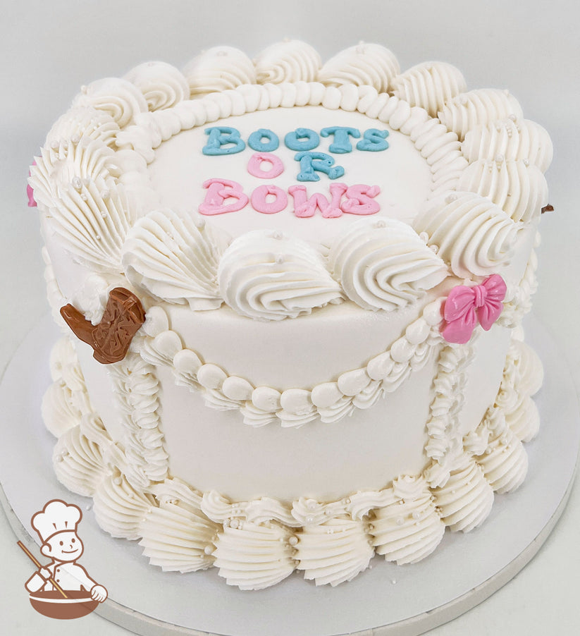 White single-tier cake with piped swirls, pearl accents, and text reading "Boots or Bows" in blue and pink. Decorated with a brown boot and pink bow.