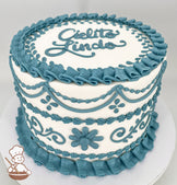 A single-tier white cake decorated with intricate blue buttercream piping, including floral patterns, swirls, and ruffled borders. The top features the text "Cielito Lindo" in blue icing.