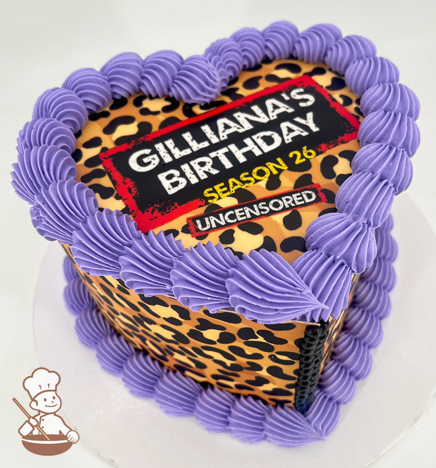 Heart-shaped cake with a leopard print design, topped with purple frosting borders. The text on top reads "Gilliana's Birthday, Season 26, Uncensored."
