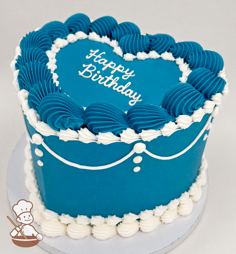 Heart-shaped cake with blue frosting, white piped borders, and "Happy Birthday" written on top. Decorated with white icing swags and dots.