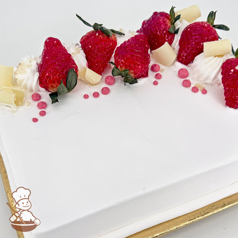 Sheet cake with white frosting, decorated with strawberries, white chocolate curls, pink buttercream dots, and whipped cream swirls.