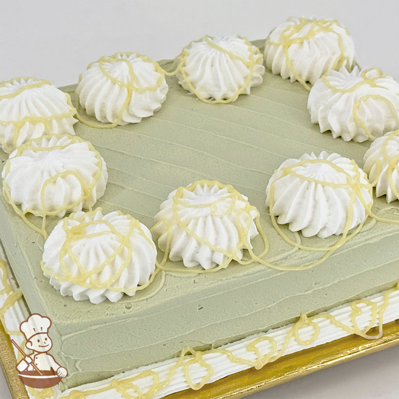 Sheet cake with green frosting, white buttercream swirls and white chocolate drizzle.