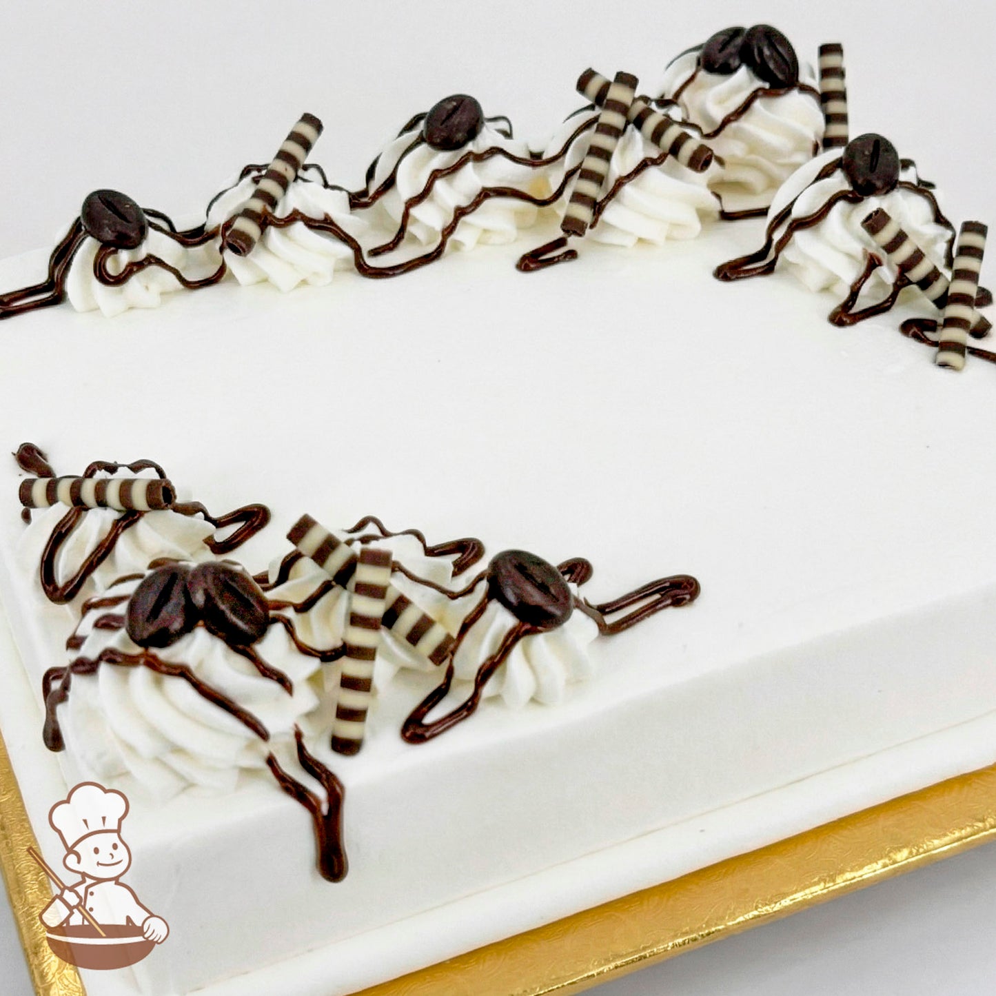 Sheet cake with white frosting, topped with chocolate ganache drizzle, striped chocolate sticks, and coffee beans.