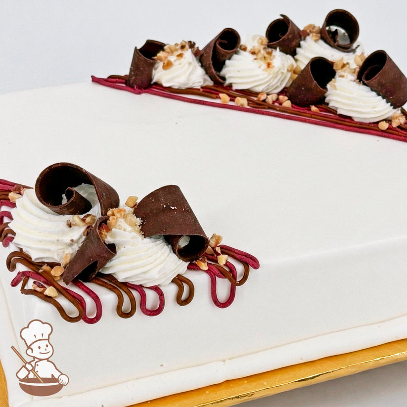 White sheet cake topped with chocolate curls, white buttercream swirls, brown and purple buttercream lines, and diced almonds.