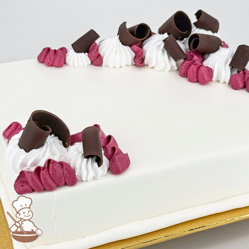 White sheet cake decorated with squiggles of purple buttercream, whipped cream swirls, and chocolate curls.