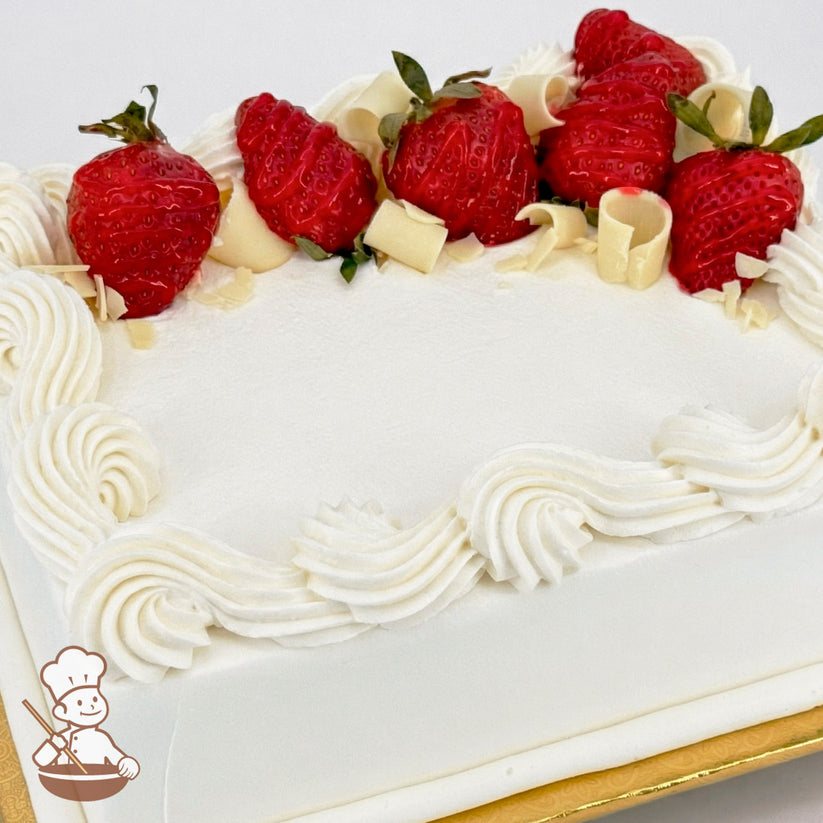 White sheet cake with buttercream swirled trim, topped with fresh strawberries and white chocolate curls.