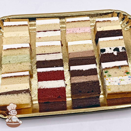 12 Cake Sample Slices arranged in a 4 by 4 grid on a gold colored tray. Slices are various flavors & are numbered 1 through 12. 1 is in the top left corner & 12 is bottom right.