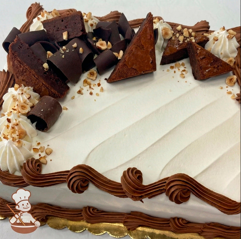 Sheet cake decorated with brownies, chocolate curls and diced hazelnuts.