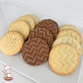 A white plate with rows of lemon, chocolate, and butter shortbread cookies.