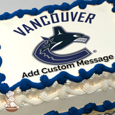 Vancouver Canucks logo with an orca whale breaking out of ice, forming a stylized "C," printed on a sheet cake.