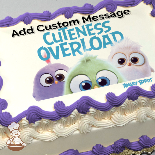 three cute, fluffy Angry Birds hatchlings with big eyes, on a sheet cake printed with the text "Cuteness Overload."