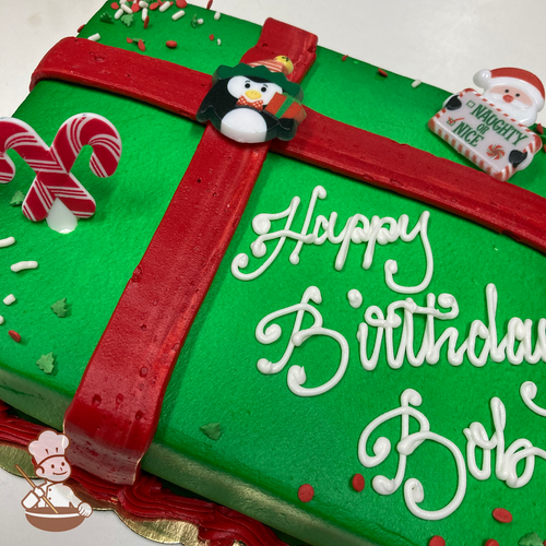 Birthday sheet cake with gift wrap design and sprinkles; and Christmas Pengiun, Santa Claus and candy cane ring toys. 