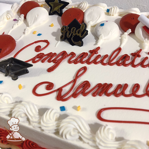 Graduation sheet cake with buttercream balloons, sprinkles and fun toy rings including grad's cap, diploma and star.