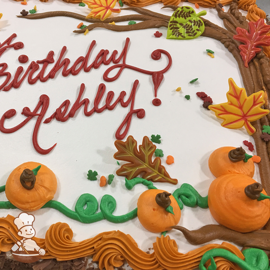 Birthday sheet cake with buttercream pumpkins and trees with leaf toys and sprinkles.