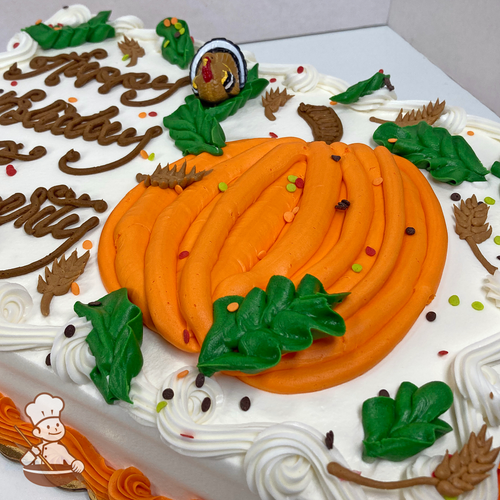 Birthday sheet cake with buttercream pumpkin, leaves, twigs and turkey toy ring and sprinkles.